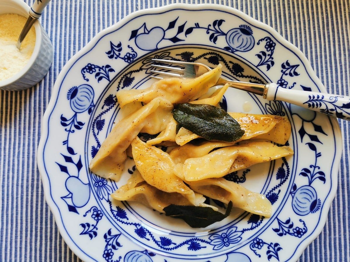 Scarpinocc di parre pasta from Lombardy on a blue and white plate.