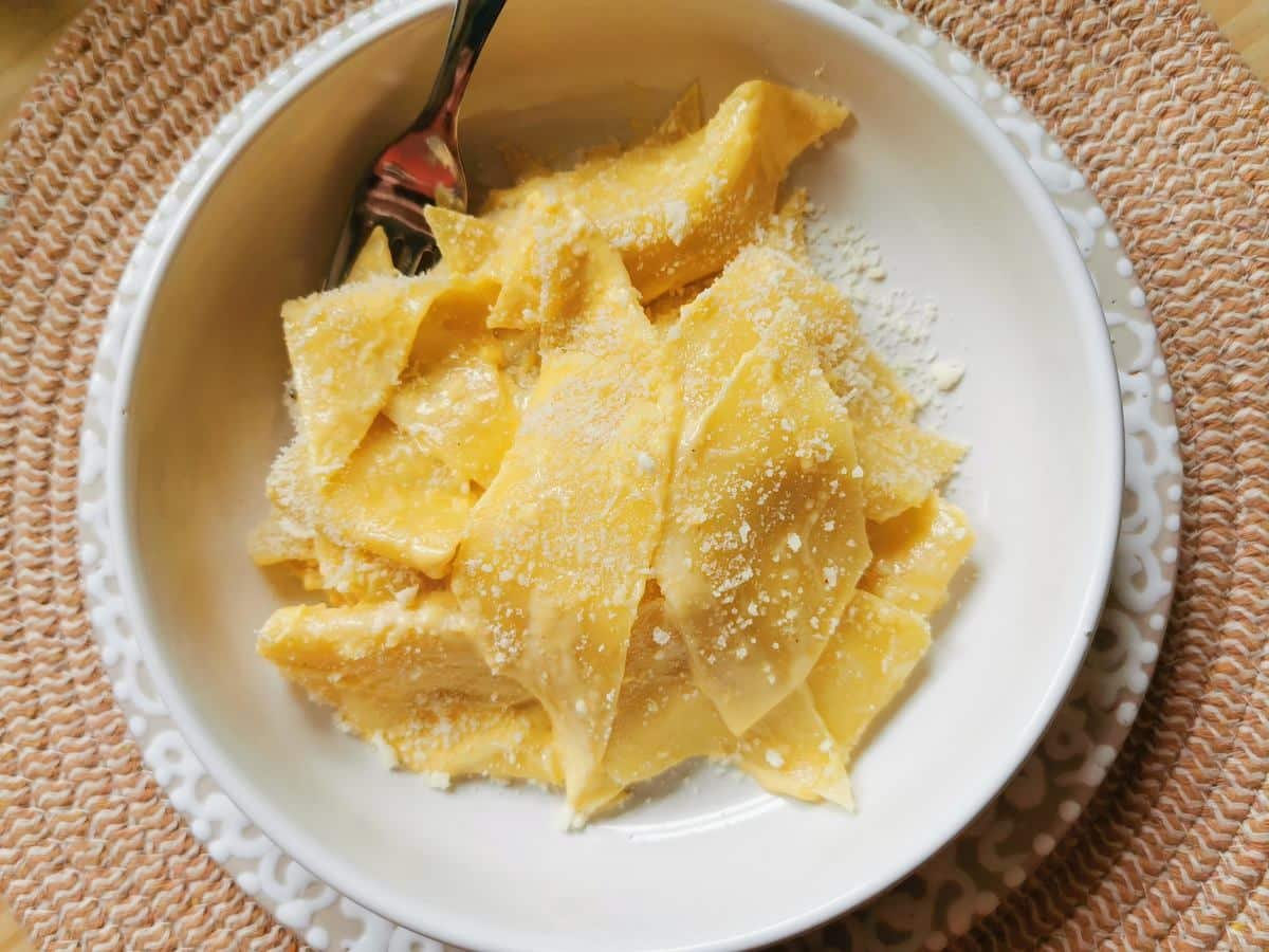 Maltagliati pasta with mascarpone in a white bowl.