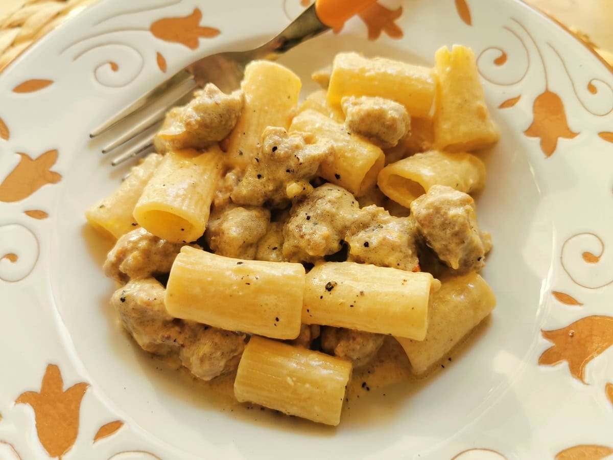 Sausage pasta alla Monzese in a white and orange bowl.