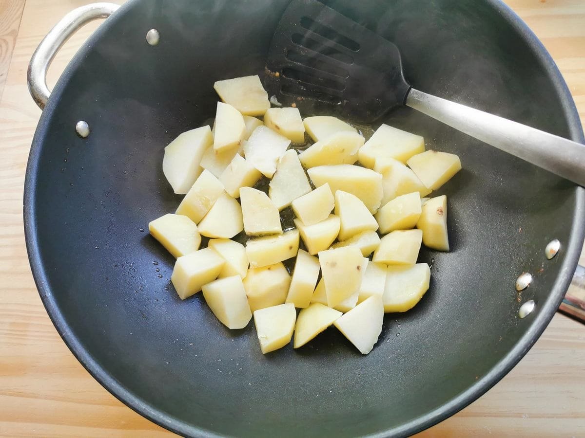 Diced potatoes are boiled in a pan.