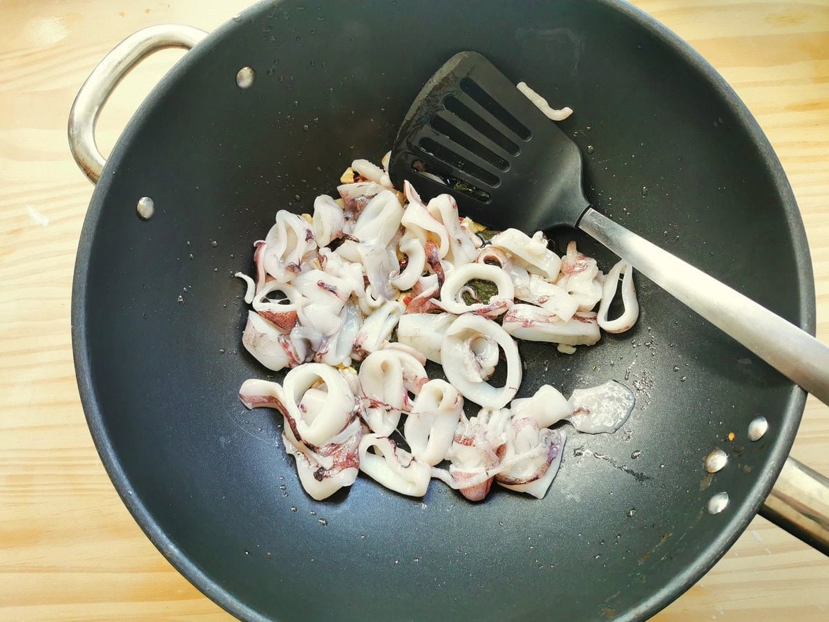 Calamari (squid) cooking in a pot with garlic.