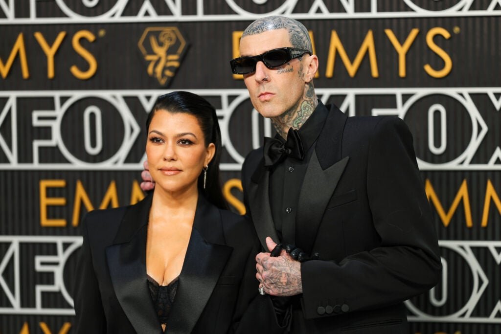 Kourtney Kardashian and Travis Barker pose on the red carpet at the Emmy Awards 2024.