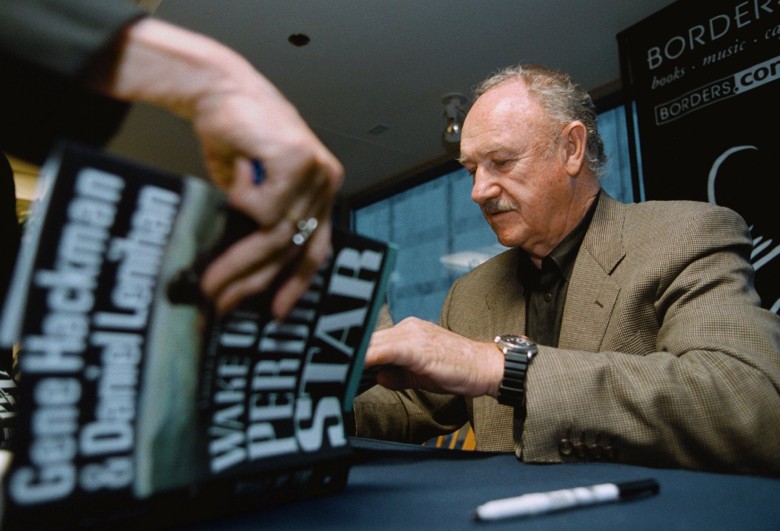 Actor Gene Hackman signs a copy of his new book