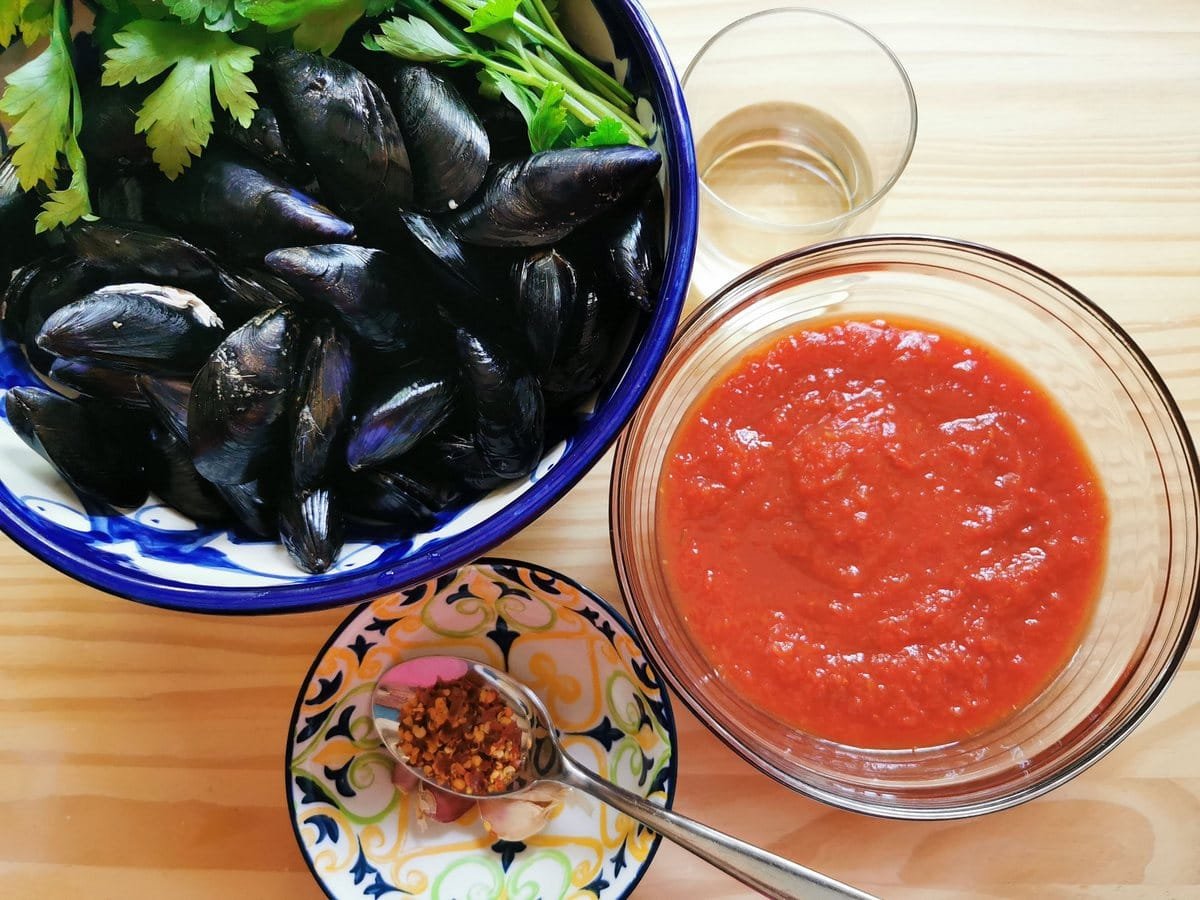 Ingredients for mussels alla tarantina; Mussels, fresh parsley, tomato passport, red chili flakes, garlic and white wine.